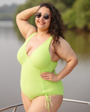 Confident Indian woman in swimwear standing at the beach, representing empowerment and modern swimwear freedom.